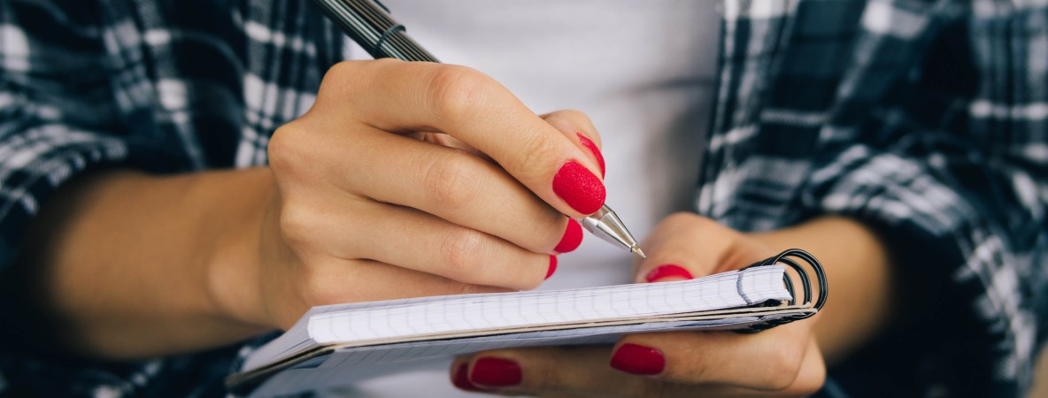 Woman-in-plaid-shirt-and-a-red-manicure-pen-writing-508541368_4898x3265_crop.jpg
