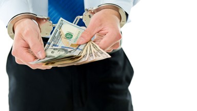 Businessman-hands-in-handcuffs-holding-US-dollars-543599726_6882x4820.jpeg