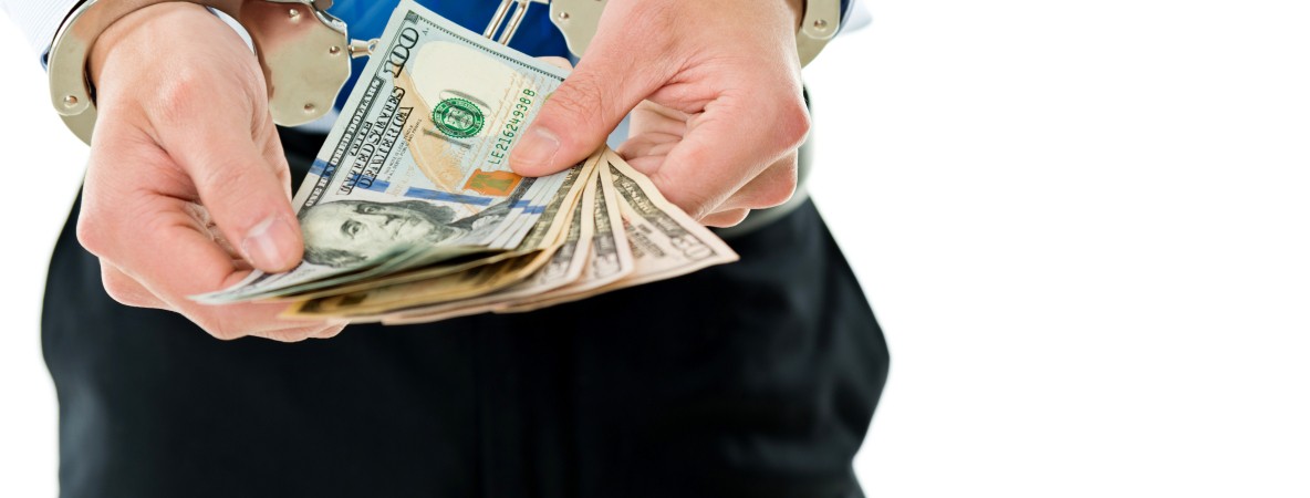 Businessman-hands-in-handcuffs-holding-US-dollars-543599726_6882x4820.jpeg