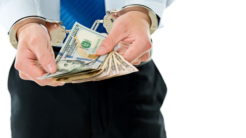 Businessman-hands-in-handcuffs-holding-US-dollars-543599726_6882x4820.jpeg
