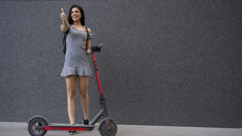 cheerful-young-woman-next-to-electric-scooter-thumbs-up-1163337952_2125x1416.jpeg