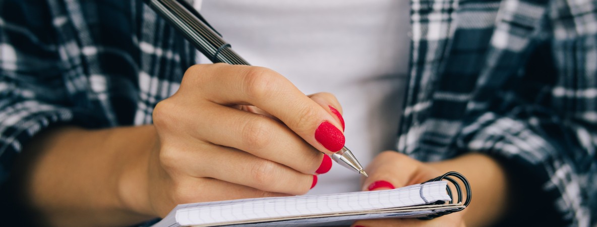 Woman-in-plaid-shirt-and-a-red-manicure-pen-writing-508541368_4898x3265.jpeg