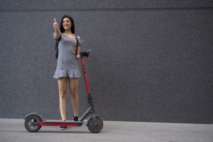 cheerful-young-woman-next-to-electric-scooter-thumbs-up-1163337952_2125x1416.jpeg
