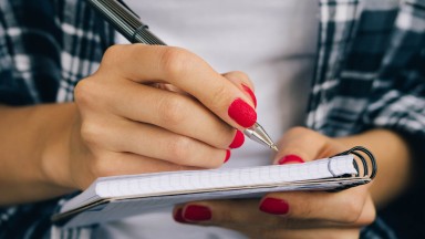 Woman-in-plaid-shirt-and-a-red-manicure-pen-writing-508541368_4898x3265_crop.jpg